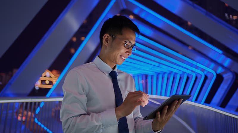 Case Study - How Market Insights Optimised Hiring & Drove Success - Asian Man On Tablet Chuanggu Road Pedestrian Bridge