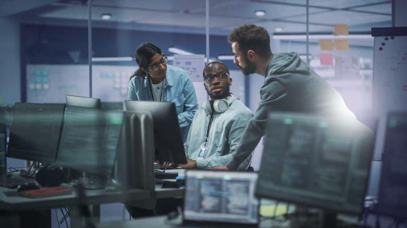 Diverse Group Of Professionals Meeting In Modern Office Working On Cybersecurity